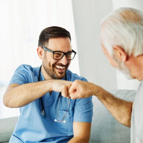 Doctor or nurse caregiver with senior man greeting each other at home or nursing home, partnership and cooperation concept