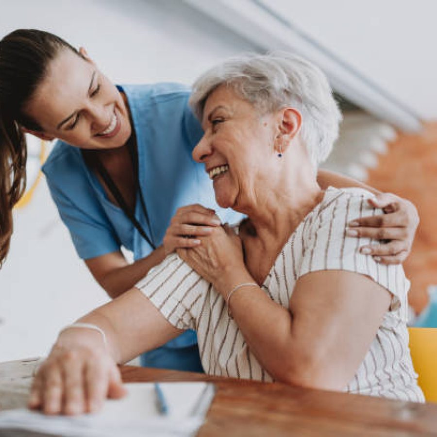 Home care healthcare professional hugging senior patient